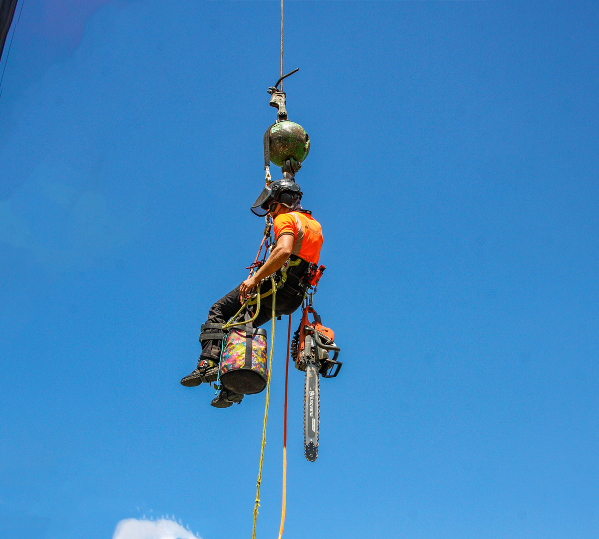 A person in safety gear is hanging on a line